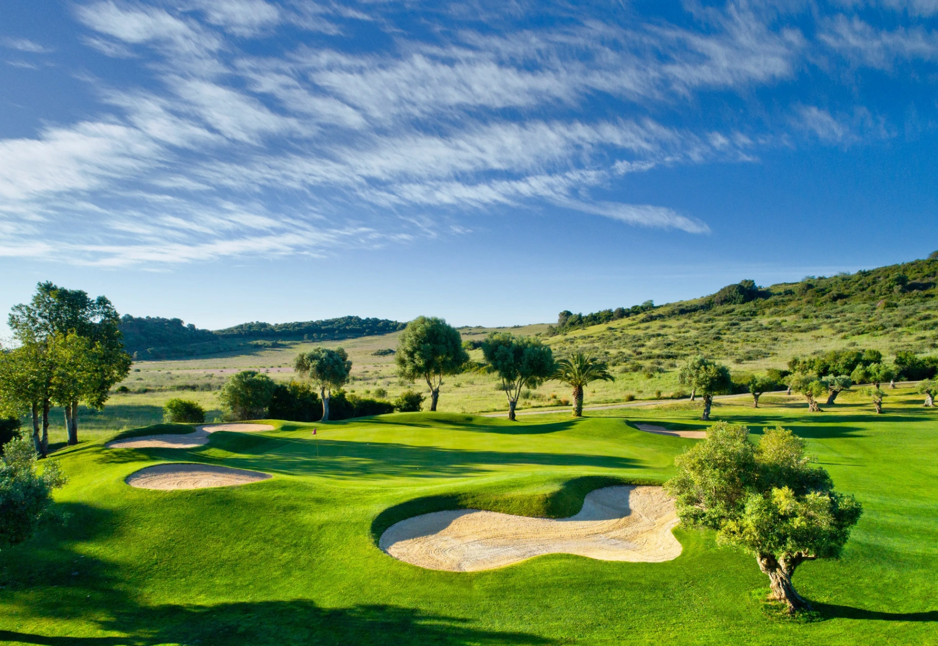 Golf course fairway with bunkers and olive trees near Estepona