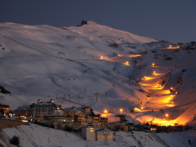 Pradollano village and floodlit ski slopes glowing at dusk in Sierra Nevada